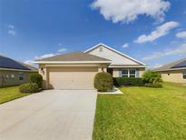 Charming single-story home featuring a well-manicured lawn, neutral color palette, and a spacious two-car garage at 1134 Legatto Loop, Dundee, FL 33838