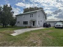 Charming two-story home featuring a driveway leading to a detached garage and a well-maintained lawn at 117 Tremont Dr, Winter Haven, FL 33884