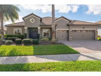 Charming single-story home with a tile roof, well-manicured lawn and a three-car garage at 1420 Mickelson Ct, Davenport, FL 33896