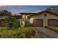 Charming Mediterranean home with a red tile roof and well-manicured landscaping at 159 Coventry Cir, Haines City, FL 33844