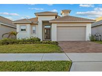 Charming single-Gathering home featuring a well-manicured lawn and a two-car garage at 168 Hampton Loop, Davenport, FL 33837