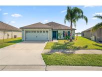 Charming single-story home with well-maintained lawn, attached two-car garage and lake view at 2443 Torrens Dr, Lakeland, FL 33805
