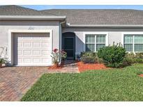 Charming single-story home with a well-manicured lawn, brick pathway, and attached single car garage at 2820 Attwater Loop, Winter Haven, FL 33884