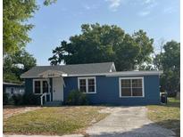 Charming blue single-story home featuring a well-kept lawn and a neatly paved driveway at 309 Lake Dale Dr, Auburndale, FL 33823