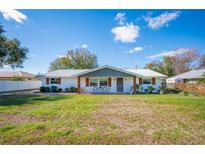 Charming single-story home featuring a metal roof, painted brick, and a welcoming front porch at 5716 Gibson Shores Dr, Lakeland, FL 33809