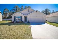 Charming single-story home featuring a well-maintained lawn and attached two-car garage at 6769 Se 3Rd Loop, Ocala, FL 34472