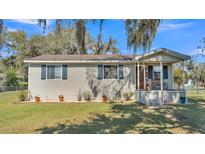 Charming single-story home featuring neutral siding, blue shutters, and a cozy front porch at 111 Klein Ct, Lakeland, FL 33813