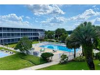 Beautiful view of the refreshing community pool with seating and lush landscaping at 1700 6Th Nw St # A36, Winter Haven, FL 33881