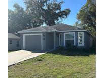 Charming single-story home features a well-maintained lawn and attached garage with a driveway at 2014 S Lake Cannon Nw Dr, Winter Haven, FL 33881