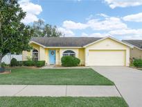 Charming single-story home with a well-manicured lawn and a bright blue front door at 2170 Country Manor St, Bartow, FL 33830