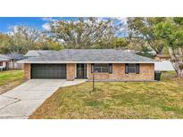 Charming single-story brick home featuring a well-maintained front yard and attached garage at 2330 Peterson Rd, Lakeland, FL 33812