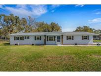 Charming single-story home featuring a well-maintained lawn and inviting entrance with Welcome sign at 2465 Thornhill Rd, Auburndale, FL 33823