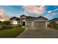 Charming single-story home with a well-manicured lawn, mature landscaping, and a two-car garage at 2726 Greyhawk Estates Ln, Lakeland, FL 33812