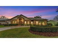 Charming brick home with a well-manicured lawn and lush landscaping at 4769 Highlands Place Cir, Lakeland, FL 33813