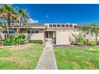 Inviting single story home featuring lush landscaping, a walkway, and a light beige exterior at 5225 Imperial Lakes Blvd # 49, Mulberry, FL 33860