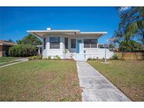 Charming bungalow featuring light blue door, a manicured lawn and a stone-clad retaining wall at 624 Woodward St, Lakeland, FL 33803