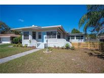 Charming single-story home featuring a manicured lawn, light blue door, and decorative exterior lighting at 624 Woodward St, Lakeland, FL 33803