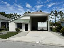 Charming single-story home featuring a covered carport and well-maintained landscaping at 1155 Motorcoach Dr, Polk City, FL 33868