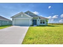 Inviting single-story home featuring a two-car garage, manicured lawn, and a charming front entryway at 4123 Tullamore Ln, Auburndale, FL 33823