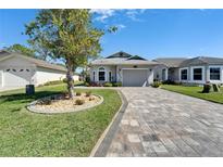 Charming single-story home with beautiful landscaping and a paver driveway at 6217 Peacock Run, Lakeland, FL 33809