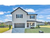 Charming two-story home with a well-manicured lawn, stylish gray garage door and lovely front porch at 6421 Highlands Oak Trl, Lakeland, FL 33813