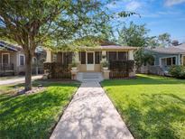 Charming single-story home with a screened front porch and well-manicured lawn and walkway at 805 Johnson Ave, Lakeland, FL 33801