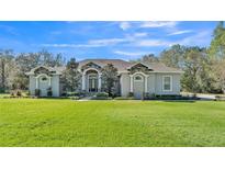 Charming single-story home featuring stone accents and a meticulously manicured front yard with a vibrant green lawn at 9216 Tom Moore Rd, Lakeland, FL 33810