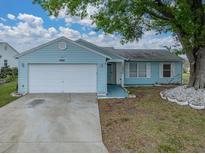 Charming light blue single-story home with a well-maintained lawn and two-car garage at 1064 Penguin Pl, Lakeland, FL 33809