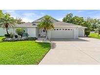 Charming single-story home with a well-manicured lawn, mature landscaping, and a three-car garage at 117 Belmont Dr, Winter Haven, FL 33884