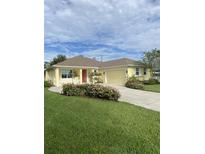 Charming one-story home with a manicured lawn, flowering shrubs, and a welcoming red front door at 3533 Britt Rd, Mount Dora, FL 32757