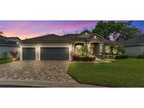 Charming single-story home featuring a manicured lawn, stone accents, and a two-car garage at 6923 Highlands Creek Ave, Lakeland, FL 33813