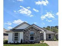 Beautiful single-story home with stone accents, well-manicured lawn, and paver driveway at 7903 Lake James Blvd, Lakeland, FL 33810