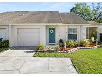 Charming single-story home featuring a well-manicured lawn, blue door, and attached one-car garage at 1021 Meadowood Pointe Rd, Lakeland, FL 33811