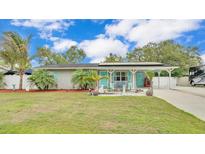 Charming single-story home featuring a covered entrance, vibrant turquoise accents, and lush landscaping at 1160 Ilene Ave, Bartow, FL 33830