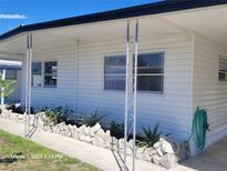 Inviting home exterior with a charming covered porch, neat landscaping, and a well-maintained white facade at 1810 Blue Lake Dr, Lakeland, FL 33801