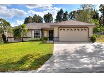 Charming single-story home features a well-maintained lawn, an attached two-car garage, and lush landscaping at 2597 Highlands Vue Pkwy, Lakeland, FL 33812