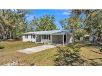 Charming single-story home with metal roof, covered carport, and well-maintained landscaping at 3035 Linda Dr, Lakeland, FL 33810