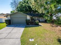 Charming single-story home featuring a well-maintained lawn and attached two car garage at 3823 Woodburn E Loop, Lakeland, FL 33813