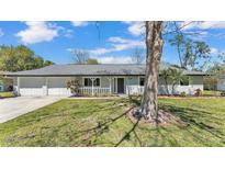 Charming single-story home with a well-manicured lawn, gray exterior paint, and a welcoming front porch at 4059 The Fenway, Mulberry, FL 33860