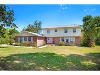 Charming two-story home with a brick facade, white shutters and a well-maintained front yard and lush landscaping at 4908 S Bedford Ln, Lakeland, FL 33813