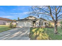 Charming single-story home featuring a well-manicured lawn and a two-car garage at 5207 St Lucia Dr, Lakeland, FL 33812