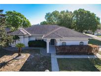 Charming single-story home featuring manicured landscaping, an arched entryway, and a well-maintained roof at 5730 Tanasi Ct, Lakeland, FL 33812