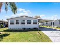 Charming single Gathering home featuring a carport, a well-kept lawn, and mature trees providing ample shade at 6634 Princeton Ne Dr, Winter Haven, FL 33881