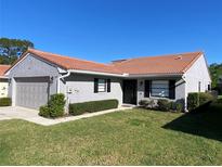 Charming single-story home featuring a well-maintained lawn and a red tile roof on a clear day at 692 Augusta Rd, Winter Haven, FL 33884