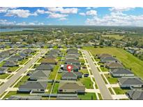 New homes are surrounded by lush landscaping and greenery, creating a peaceful and inviting atmosphere with water views at 925 First Dr, Eagle Lake, FL 33839