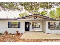 Charming home featuring a brick exterior, black shutters, and a welcoming front porch swing at 135 Kenilwood Ln, Lakeland, FL 33809