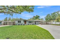 Charming single-story home with fresh green lawn, carport, neutral paint, and orange front door at 1619 Salesberry St, Lakeland, FL 33803