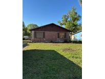 Single story brick house with overgrown lawn and boarded up windows at 2610 Tennessee Rd, Lakeland, FL 33815