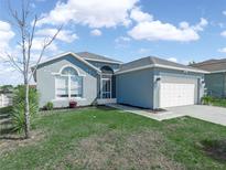 Charming single Gathering home with a two car garage and well-manicured lawn at 300 Keswick Ave, Davenport, FL 33897