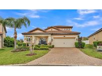 Charming single-Gathering home featuring a brick driveway, tile roof, and well-maintained landscaping at 3919 Vista Trace Way, Lakeland, FL 33810